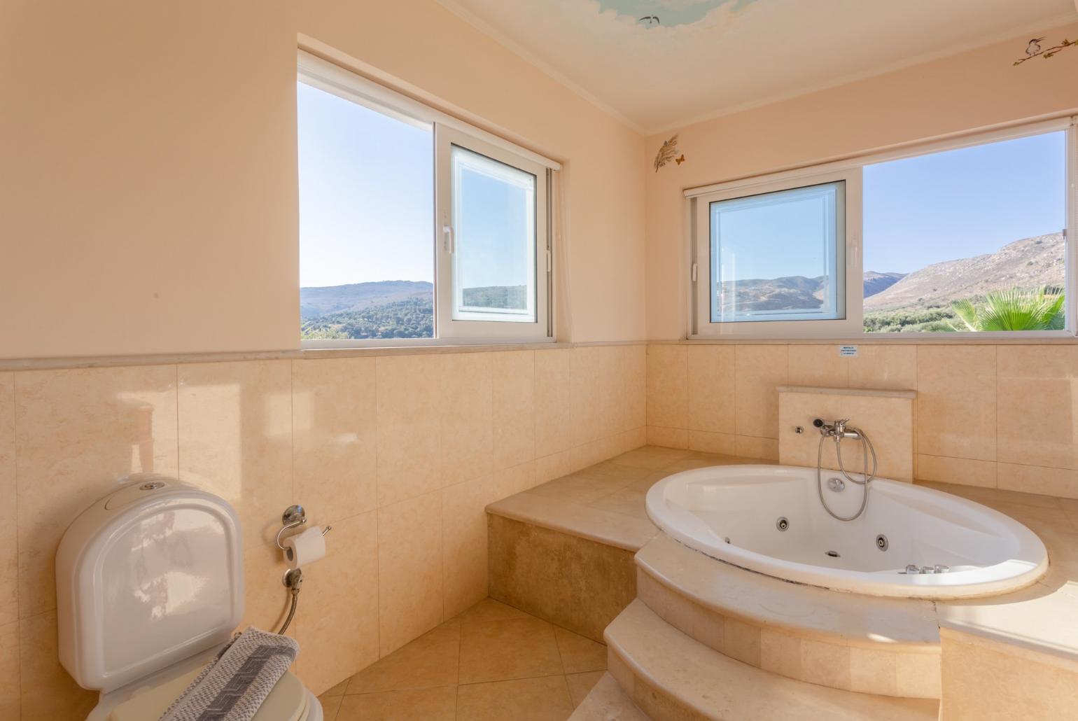 En suite bathroom with jacuzzi and shower