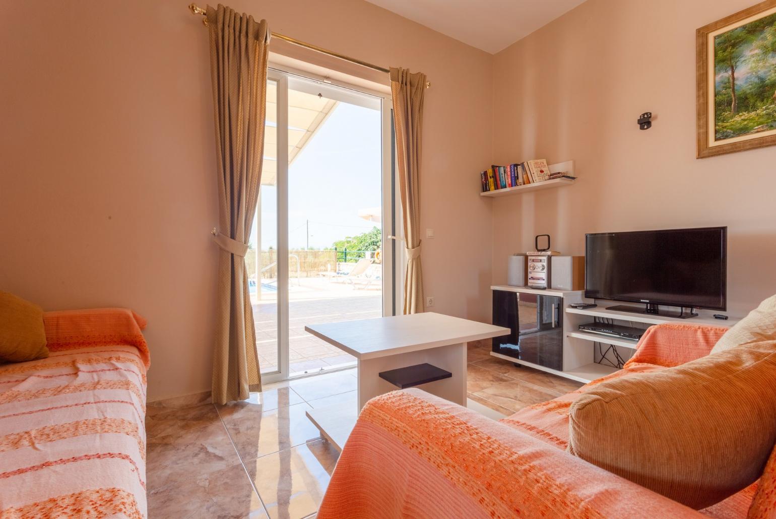 Open-plan living room with dining area, kitchen, terrace access, A/C, WiFi Internet, Satellite TV, and DVD player