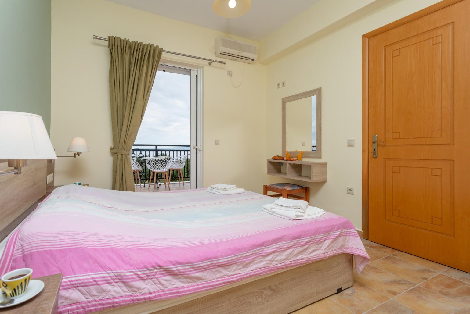 Double bedroom with en suite bathroom, A/C, and balcony access