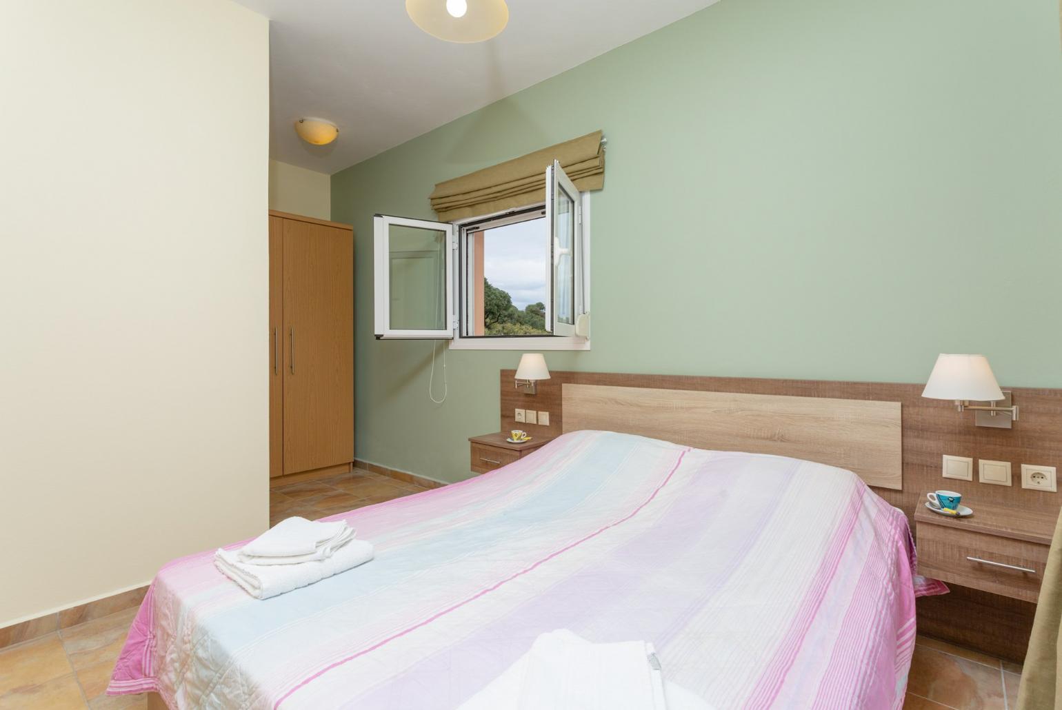 Double bedroom with en suite bathroom, A/C, and balcony access