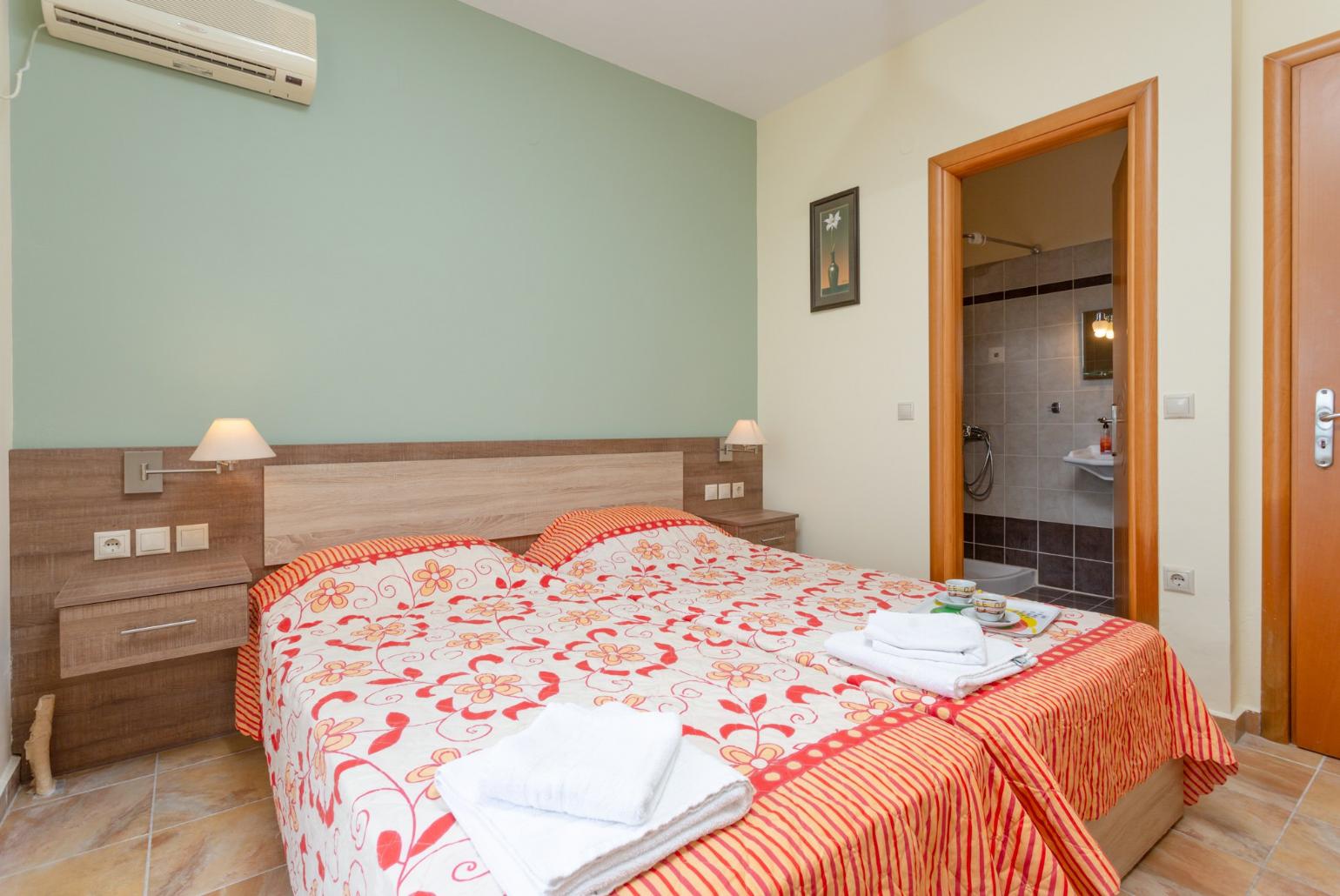 Twin bedroom with en suite bathroom, A/C, and balcony access