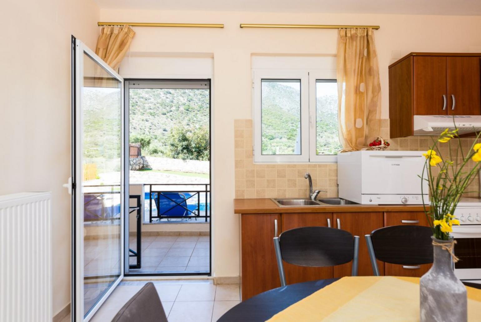 Equipped kitchen with dining area and terrace access