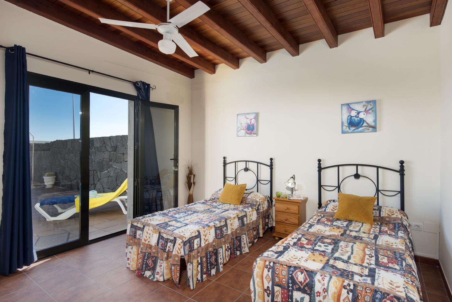 Twin bedroom with ceiling fan and terrace access