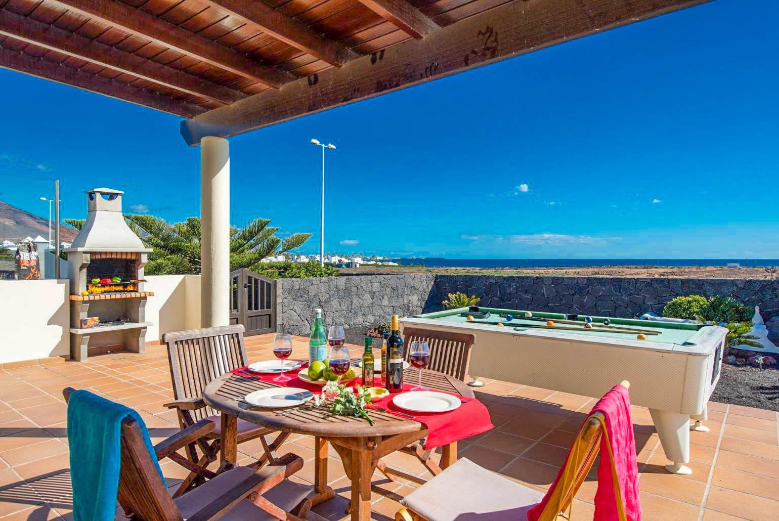 Sheltered dining area with outdoor BBQ and pool table 