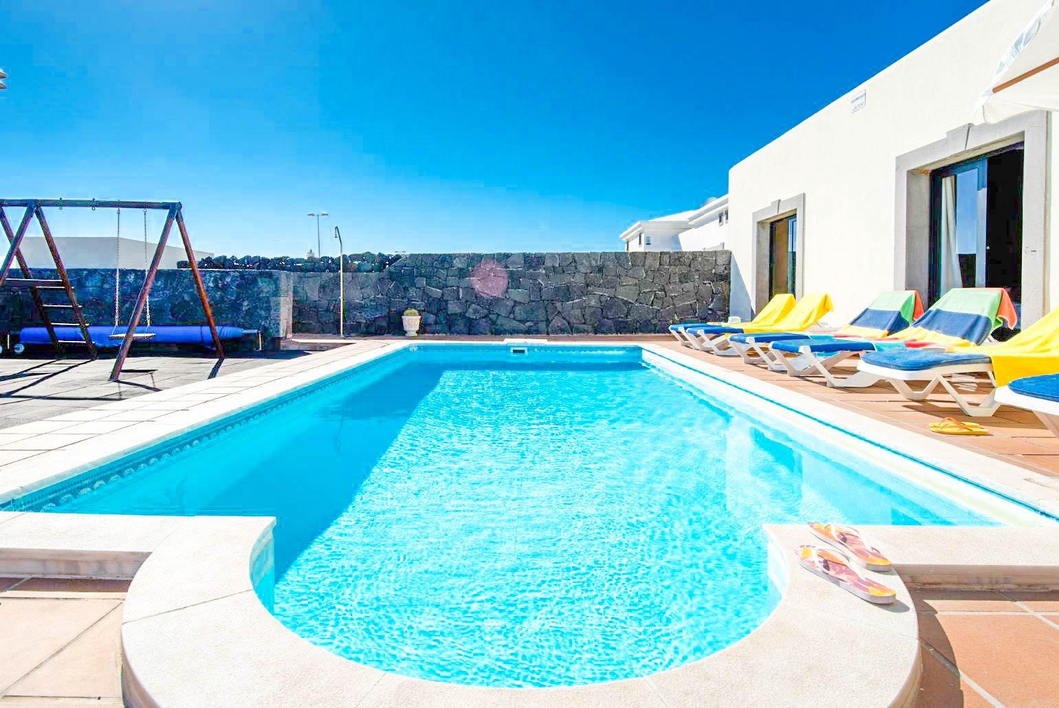 Pool area with sunbeds and parasol