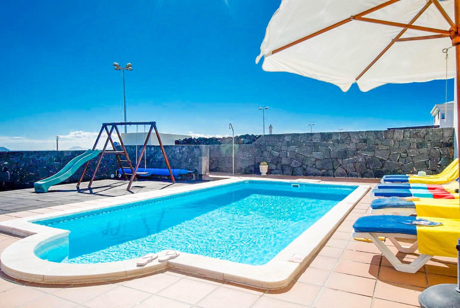 Pool area with sunbeds and parasol