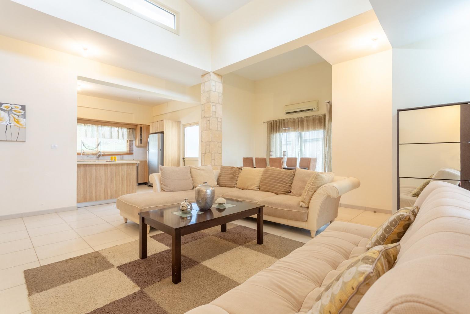 Open-plan living room with sofas, dining area, kitchen, ornamental fireplace, A/C, WiFi internet, satellite TV, DVD player, and terrace access