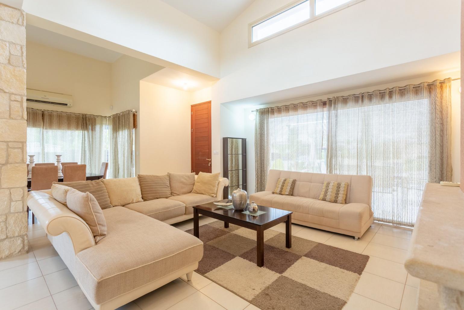 Open-plan living room with sofas, dining area, kitchen, ornamental fireplace, A/C, WiFi internet, satellite TV, DVD player, and terrace access