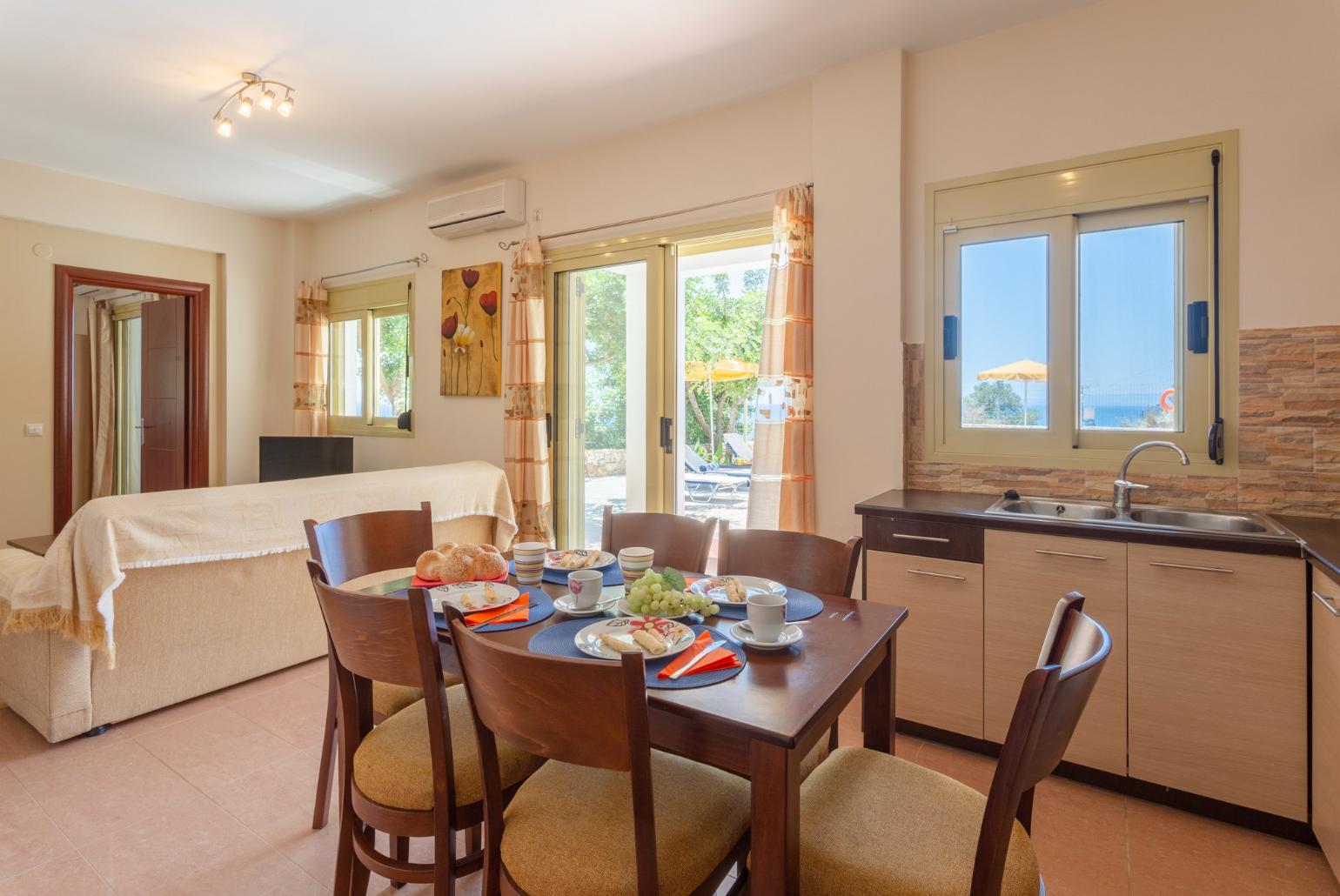 Open-plan living room with dining area, equipped kitchen, terrace access, WiFi Internet, Satellite TV, and DVD player 