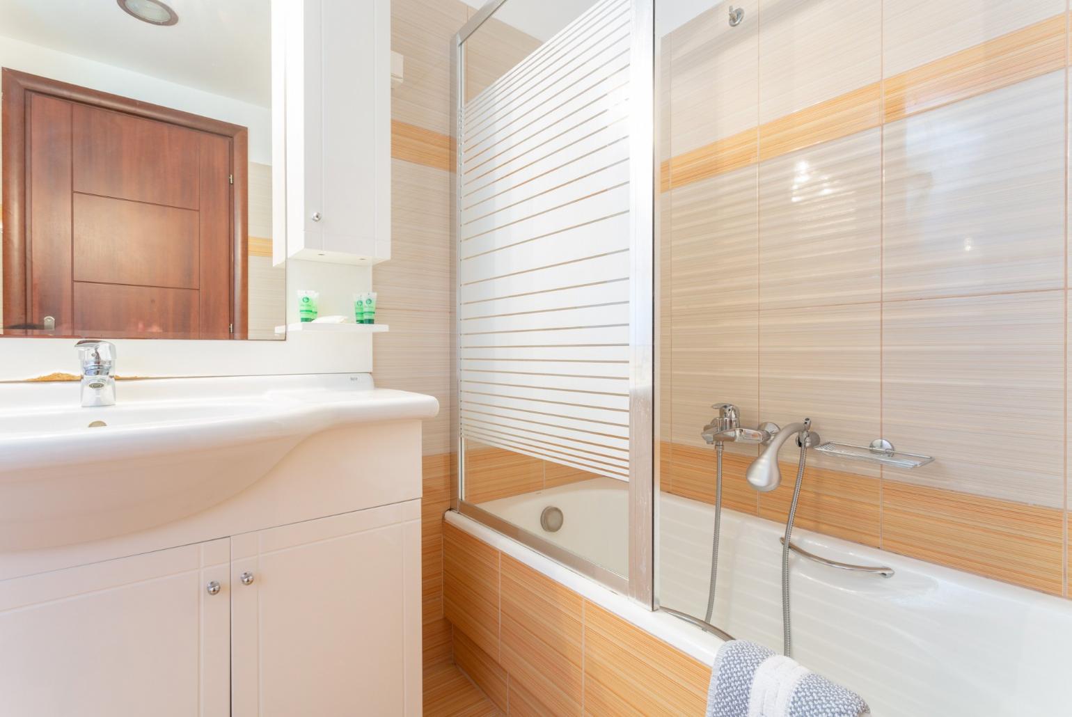 En suite bathroom with bath and overhead shower