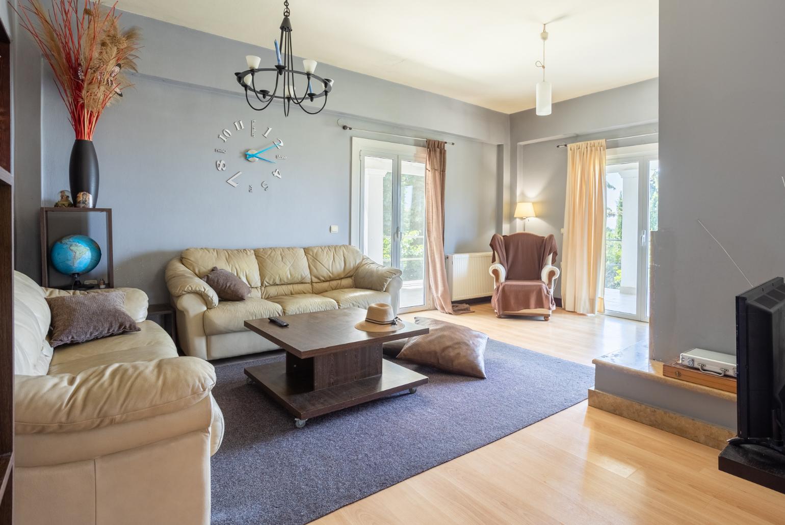 Open-plan living room with sofas, dining area, kitchen, ornamental fireplace, WiFi internet, and satellite TV