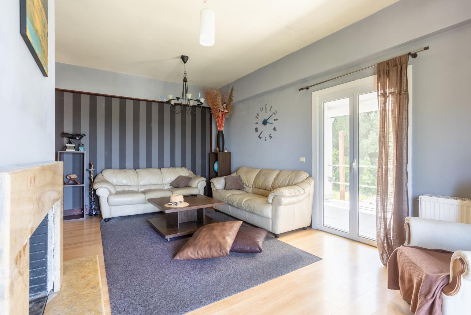 Open-plan living room with sofas, dining area, kitchen, ornamental fireplace, WiFi internet, and satellite TV