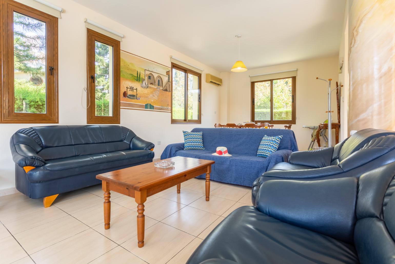 Open-plan living room with sofas, dining area, kitchen, A/C, WiFi internet, satellite TV, and terrace access