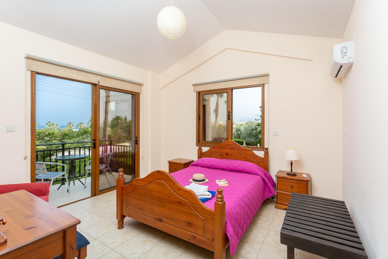 Double bedroom with en suite bathroom, A/C, and balcony access