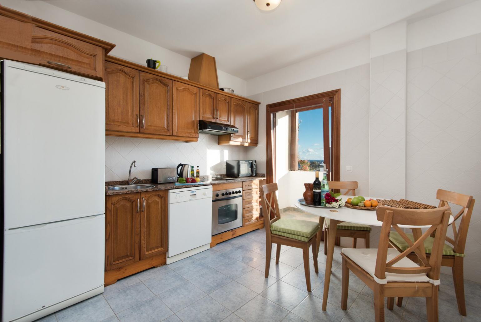 Equipped kitchen and dining are with balcony access