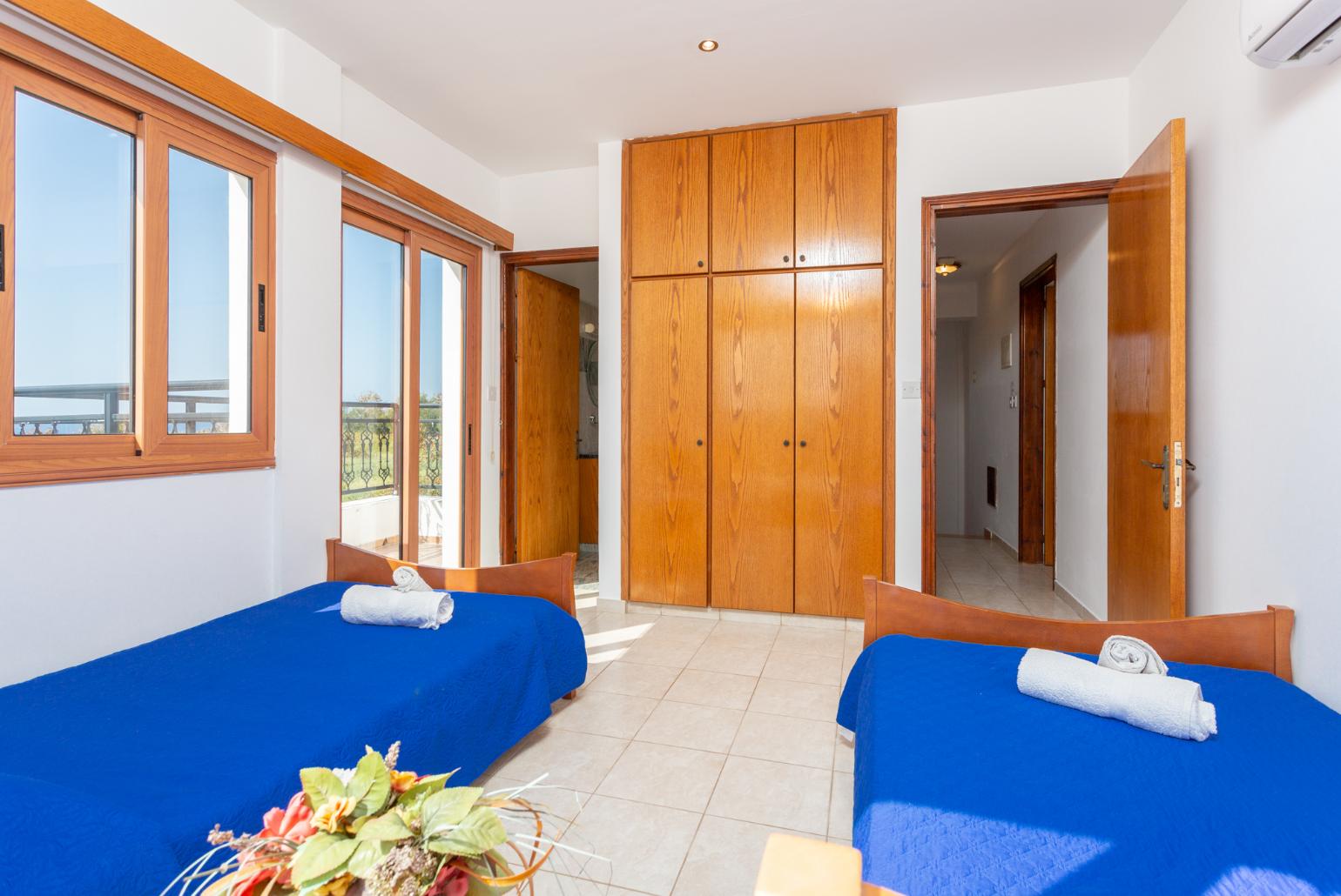 Twin bedroom with en suite bathroom, A/C, sea views, and balcony access