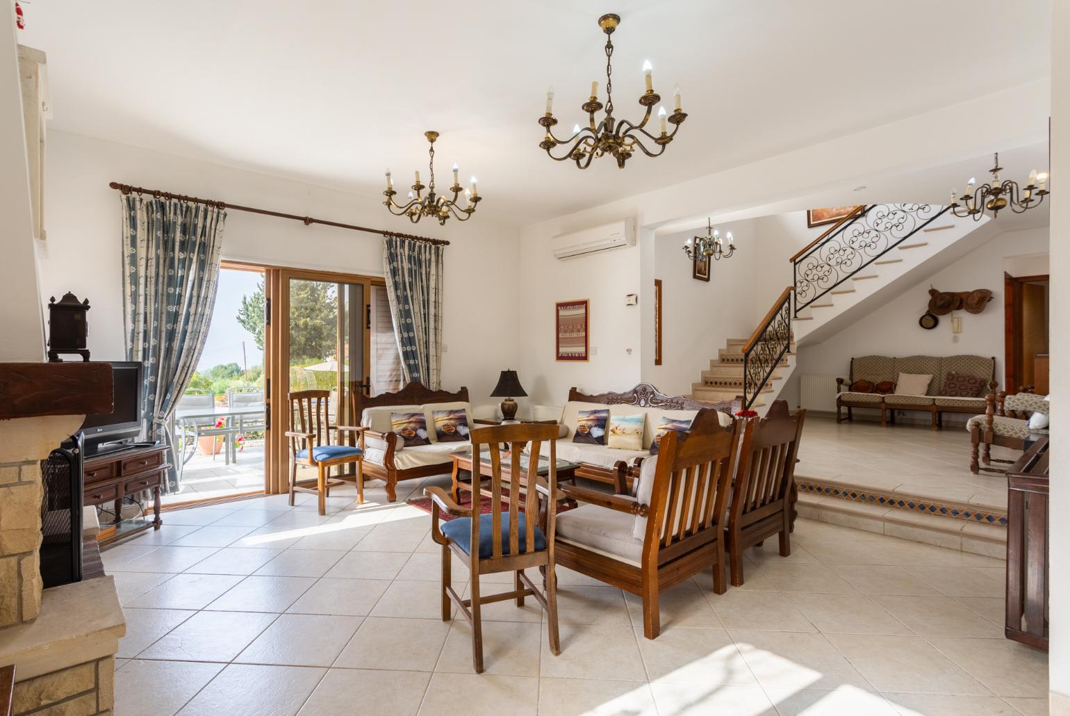 Open-plan living room with sofas, dining area, kitchen, ornamental fireplace, A/C, WiFi internet, and satellite TV