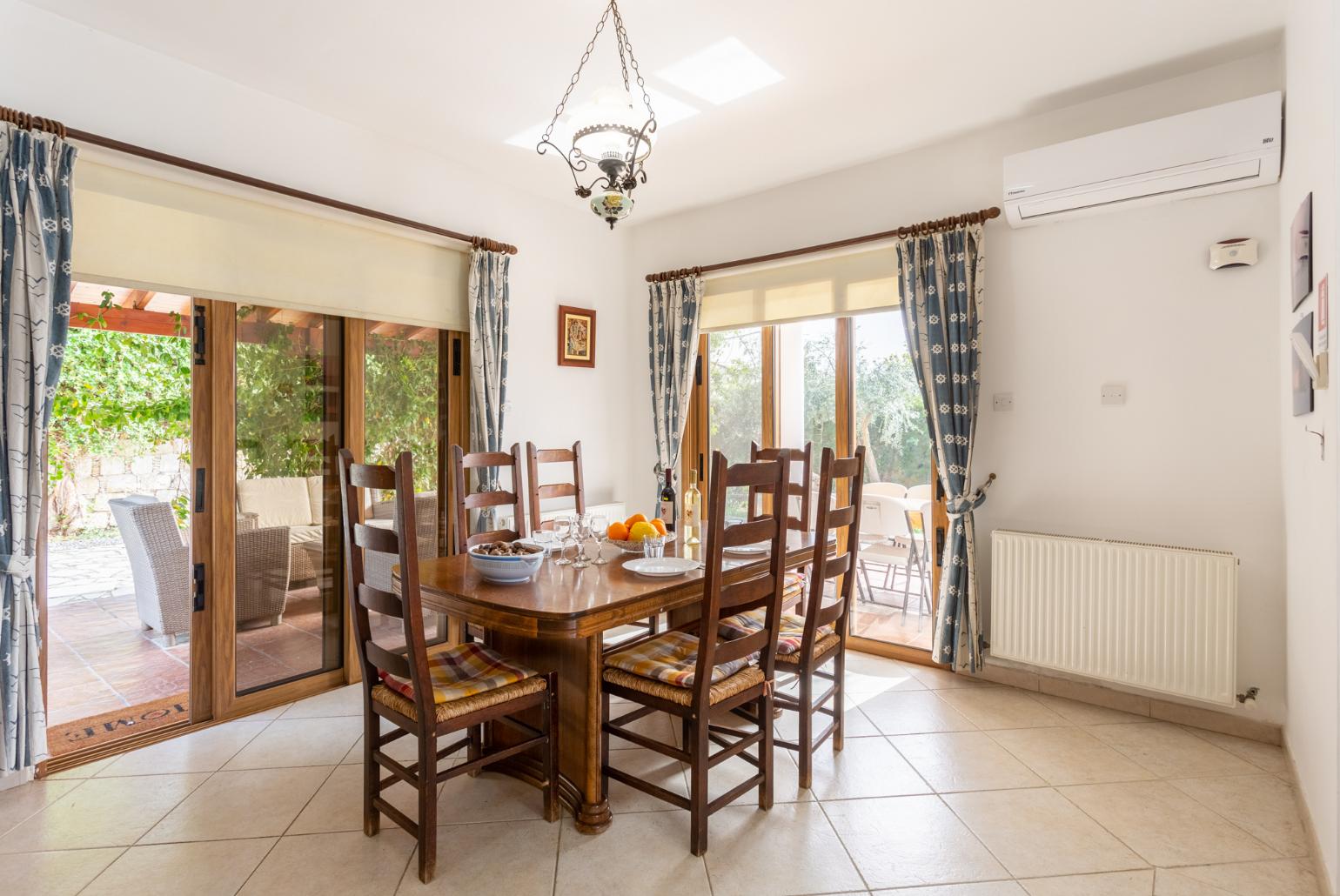 Open-plan living room with sofas, dining area, kitchen, ornamental fireplace, A/C, WiFi internet, and satellite TV