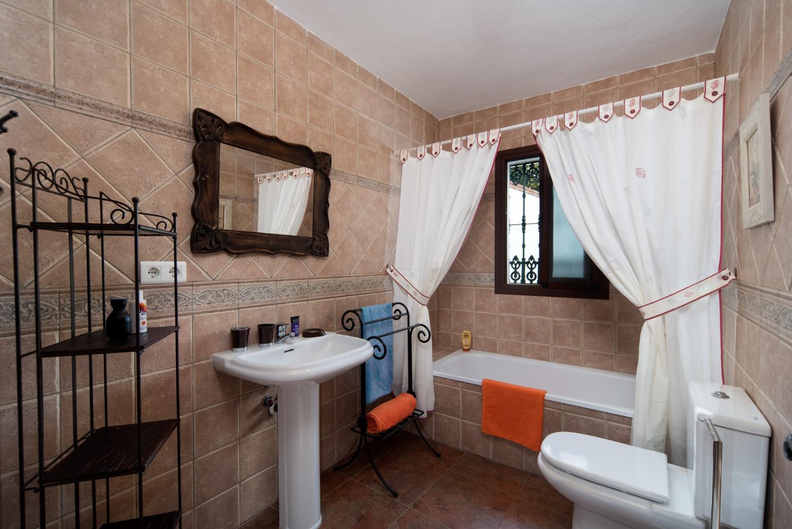 Family bathroom, bath with shower. W/C.