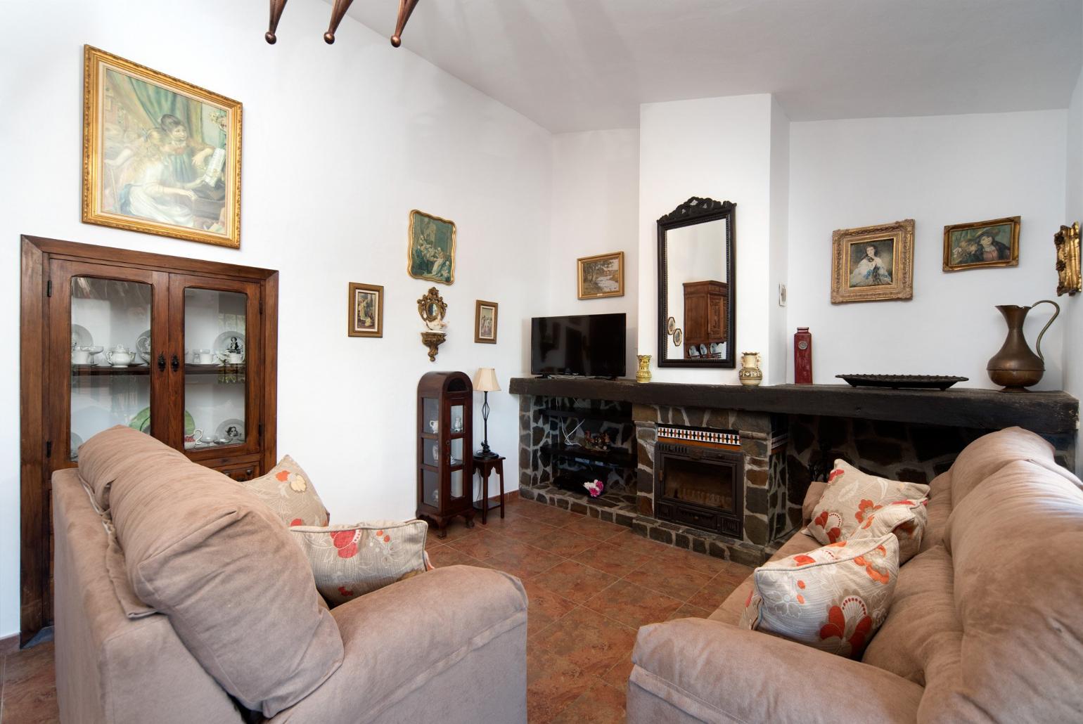 Living room with sofas, dining area, ornamental fireplace, A/C, WiFi internet, satellite TV, DVD player, and terrace access