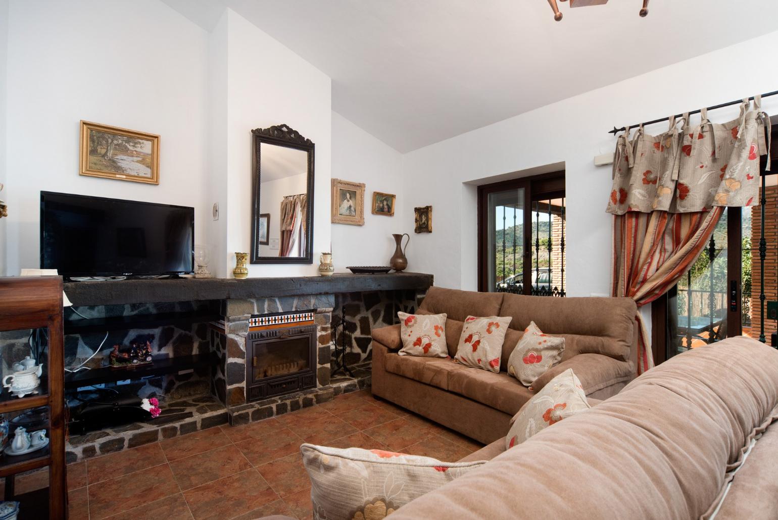 Living room with sofas, dining area, ornamental fireplace, A/C, WiFi internet, satellite TV, DVD player, and terrace access