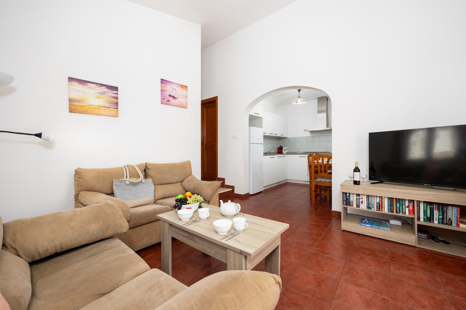 Open-plan living room with sofas, dining area, kitchen, WiFi internet, and satellite TV