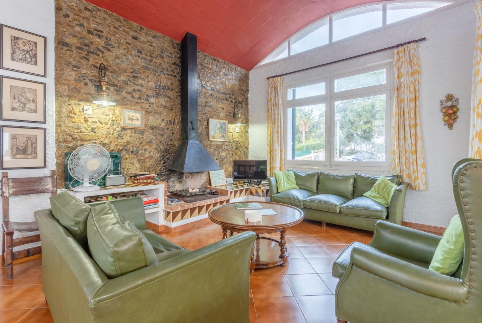 Living room with sofas, dining area, ornamental fireplace, WiFi internet, satellite TV, DVD player, and terrace access