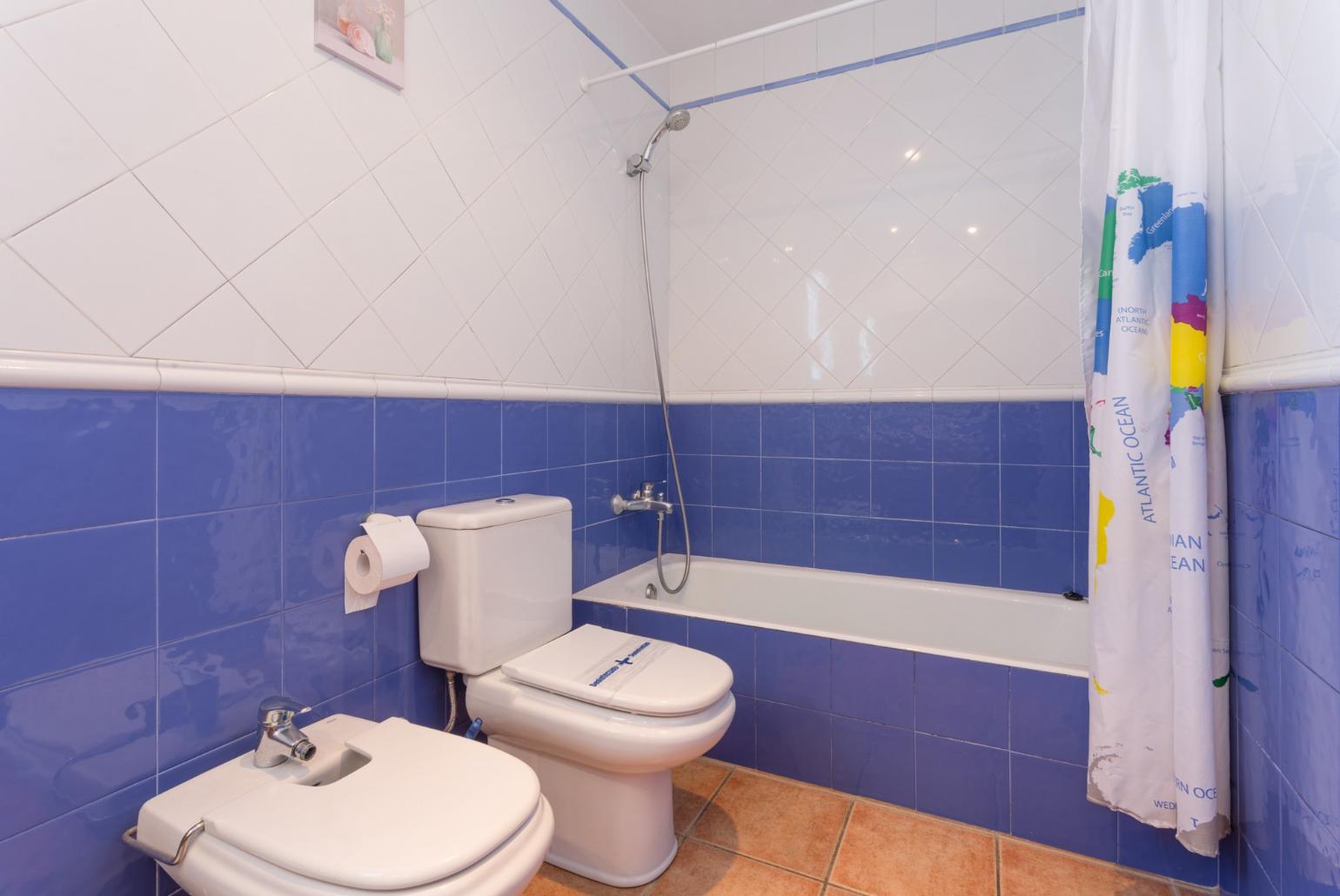 En suite bathroom with bath and overhead shower