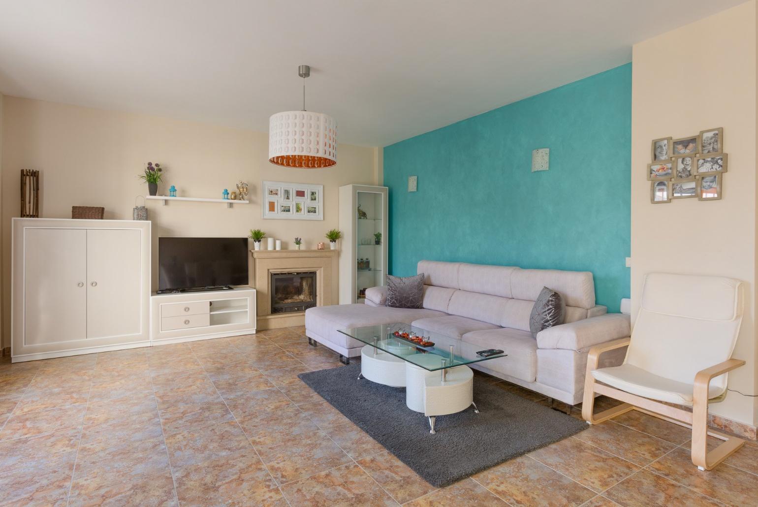 Open-plan living room with has sofas, WiFi Internet, Satellite TV, DVD player, dining area and ornamental fire place.