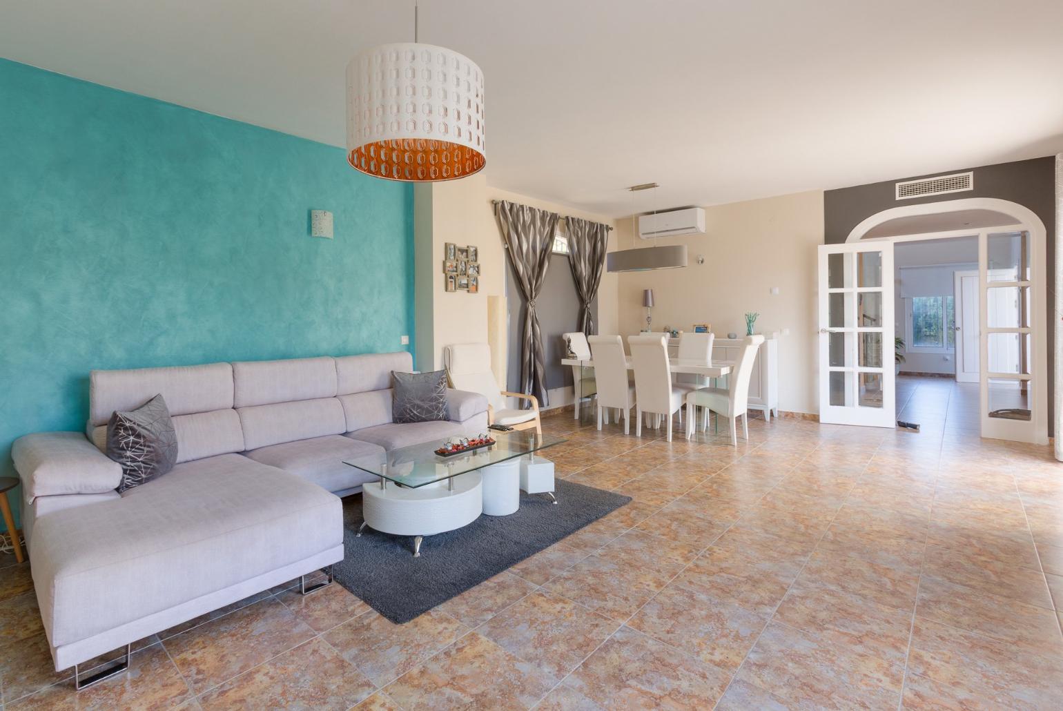 Open-plan living room with has sofas, WiFi Internet, Satellite TV, DVD player, dining area and ornamental fire place.