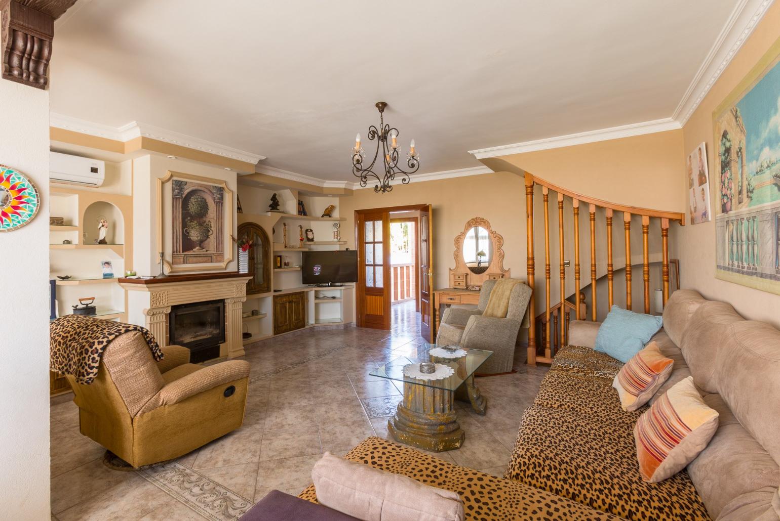 Open-plan living room with ornamental fireplace, TV and dining area