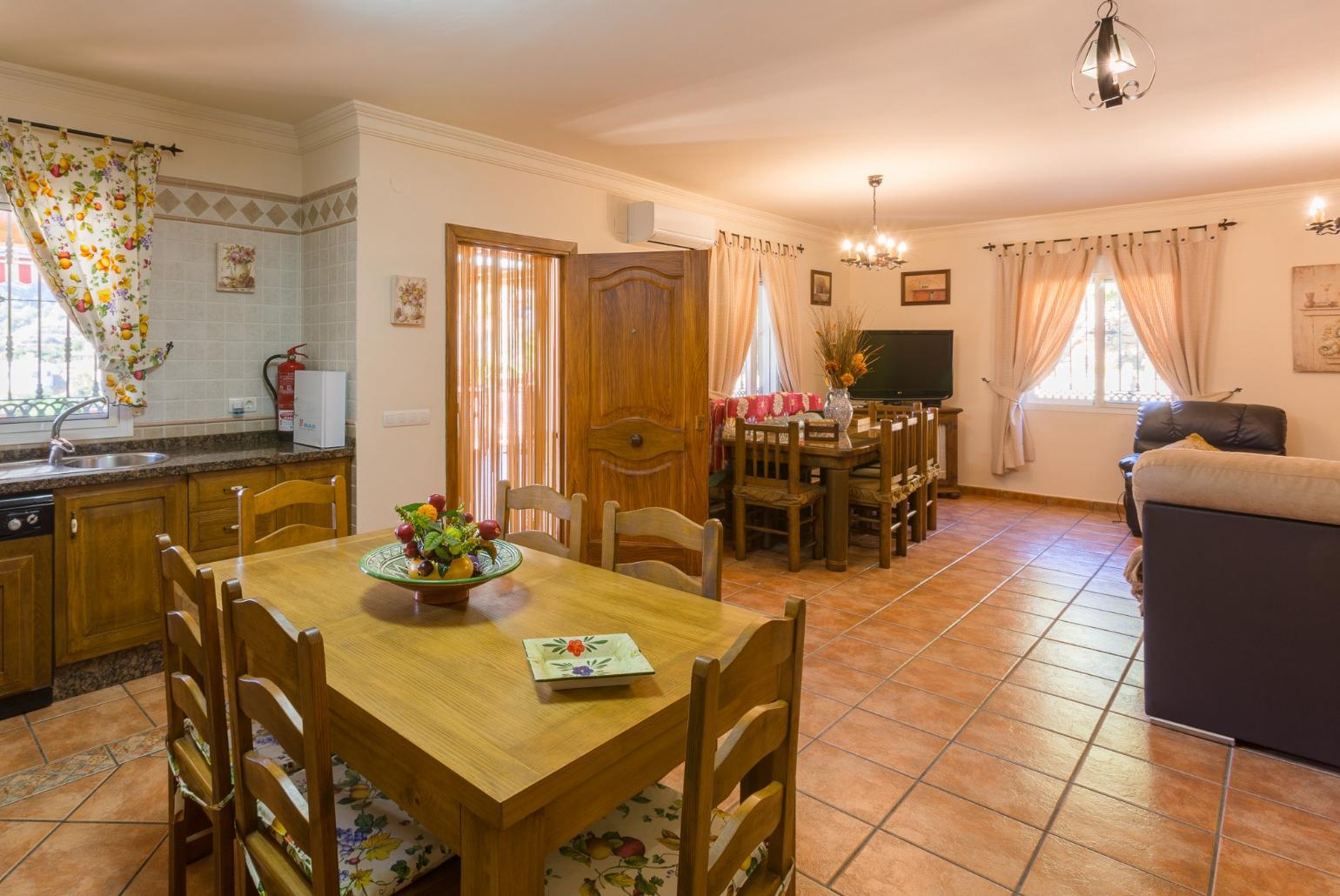 Open-plan living room with sofas, dining area, kitchen, ornamental fireplace, A/C, WiFi internet, satellite TV, DVD player, and terrace access