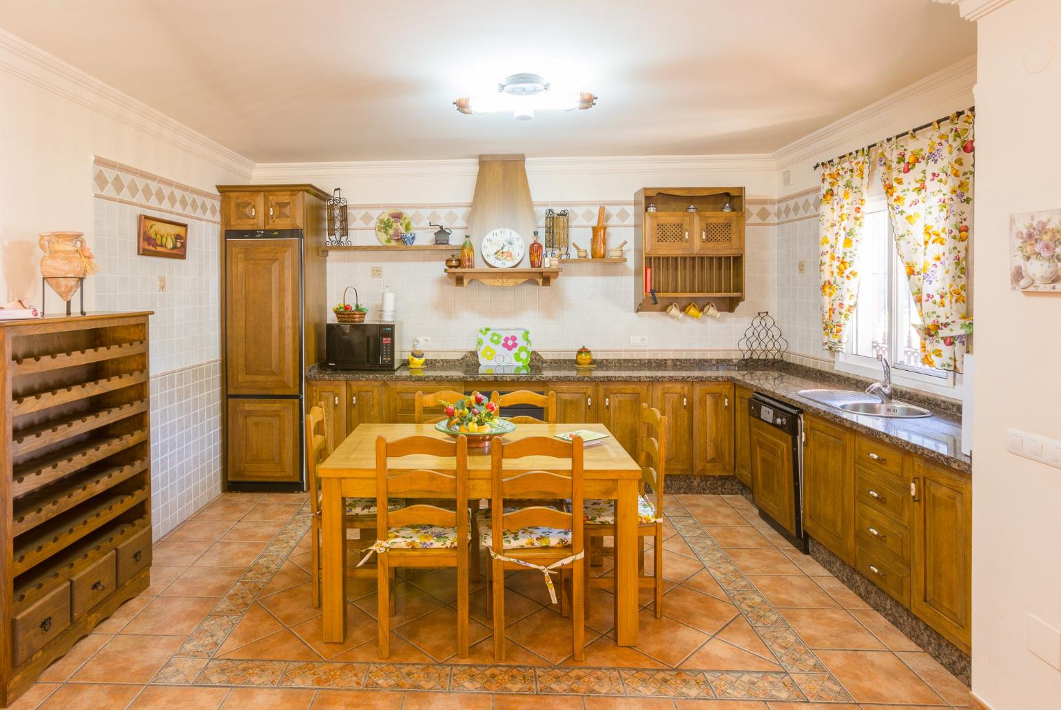 Open-plan living room with sofas, dining area, equipped kitchen, ornamental fireplace, A/C, WiFi internet, satellite TV, DVD player, and terrace access
