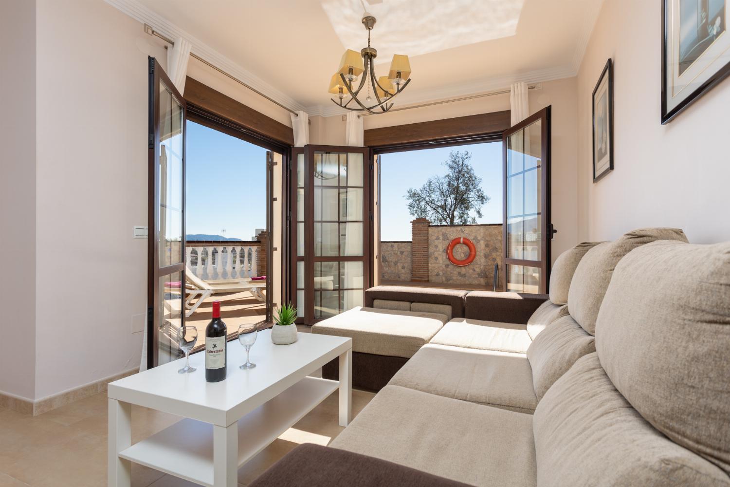 Living room with sofa, dining area, ornamental fireplace, A/C, WiFi internet, and satellite TV