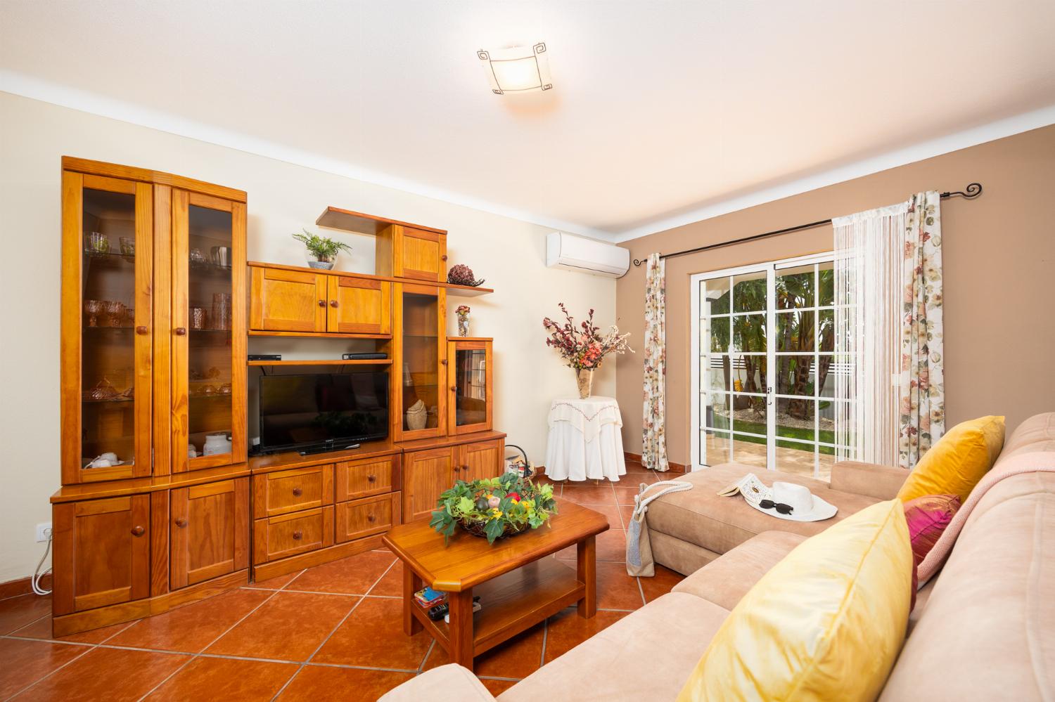 Living room with sofa, dining area, ornamental fireplace, A/C, WiFi internet, and satellite TV