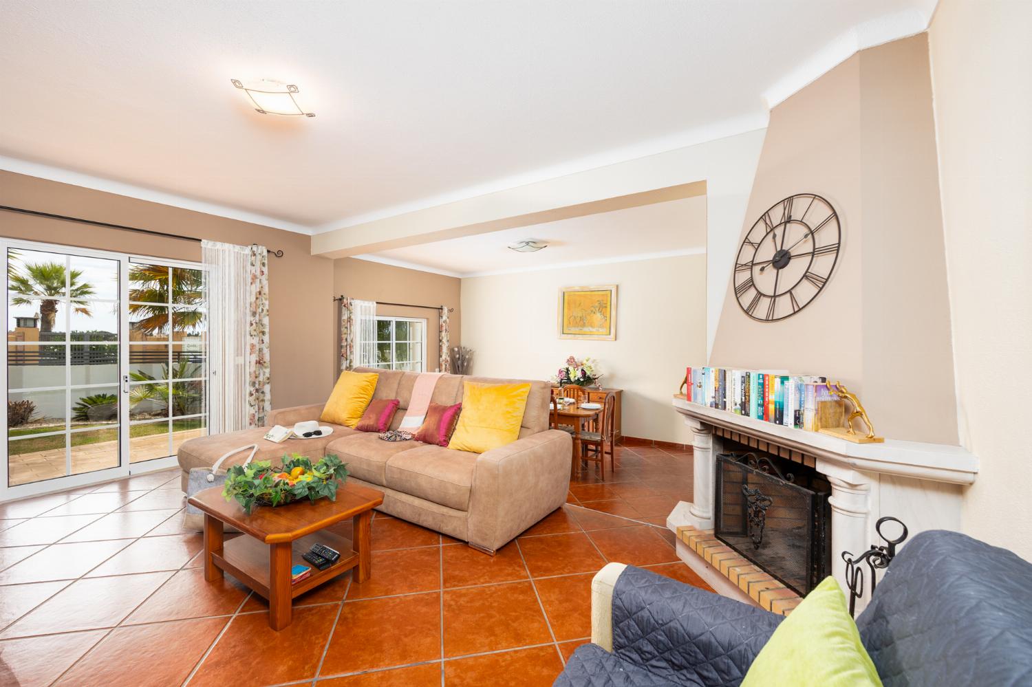 Living room with sofa, dining area, ornamental fireplace, A/C, WiFi internet, and satellite TV