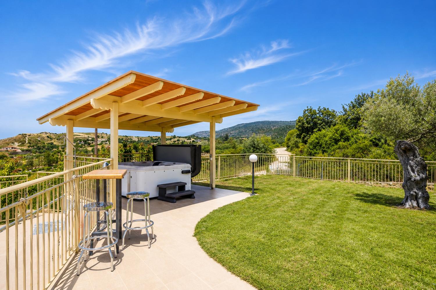Private garden terrace with a shaded jacuzzi area and beautiful countryside views.