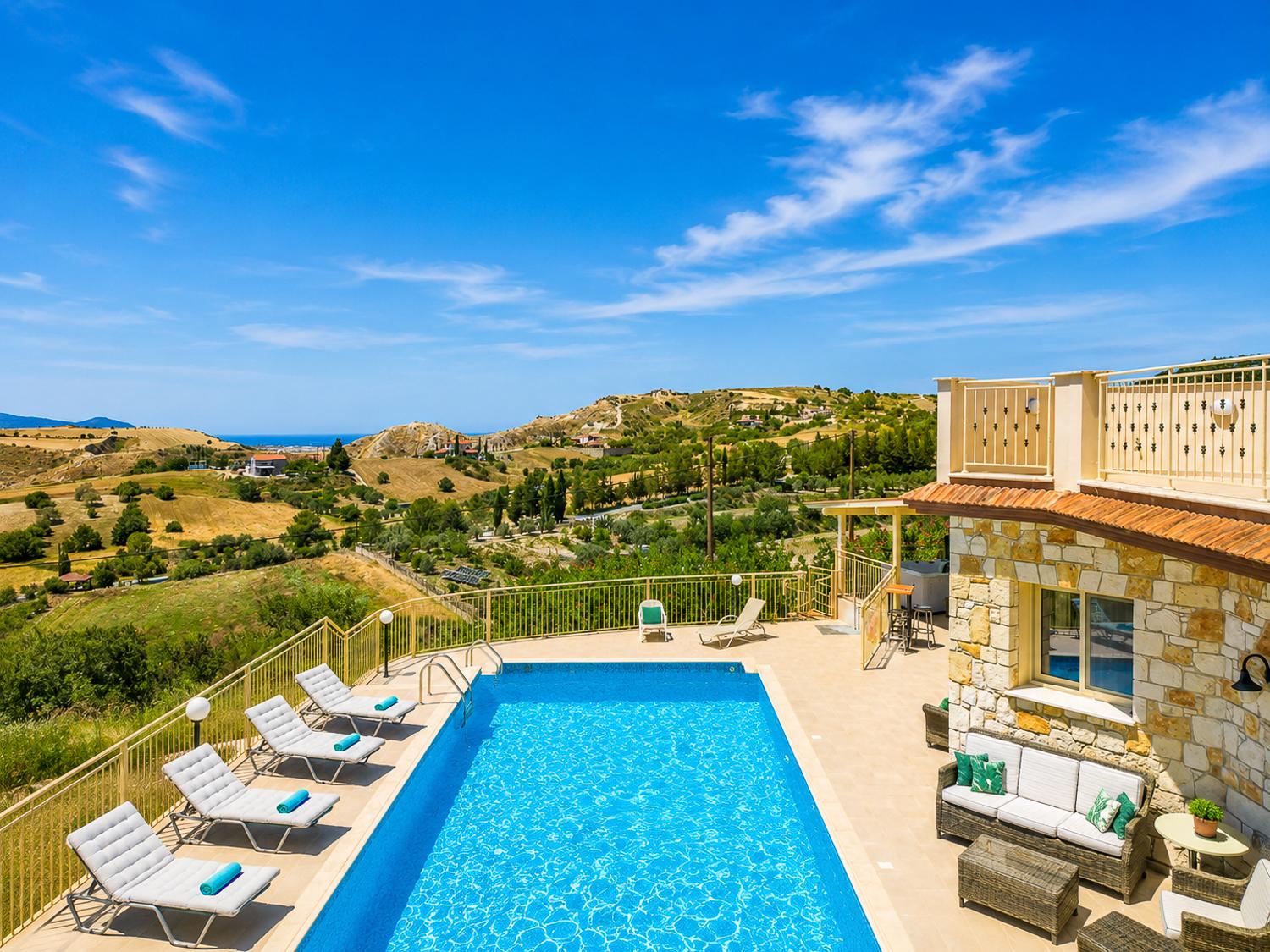 Private pool terrace with sun loungers, outdoor seating, and stunning panoramic countryside views.