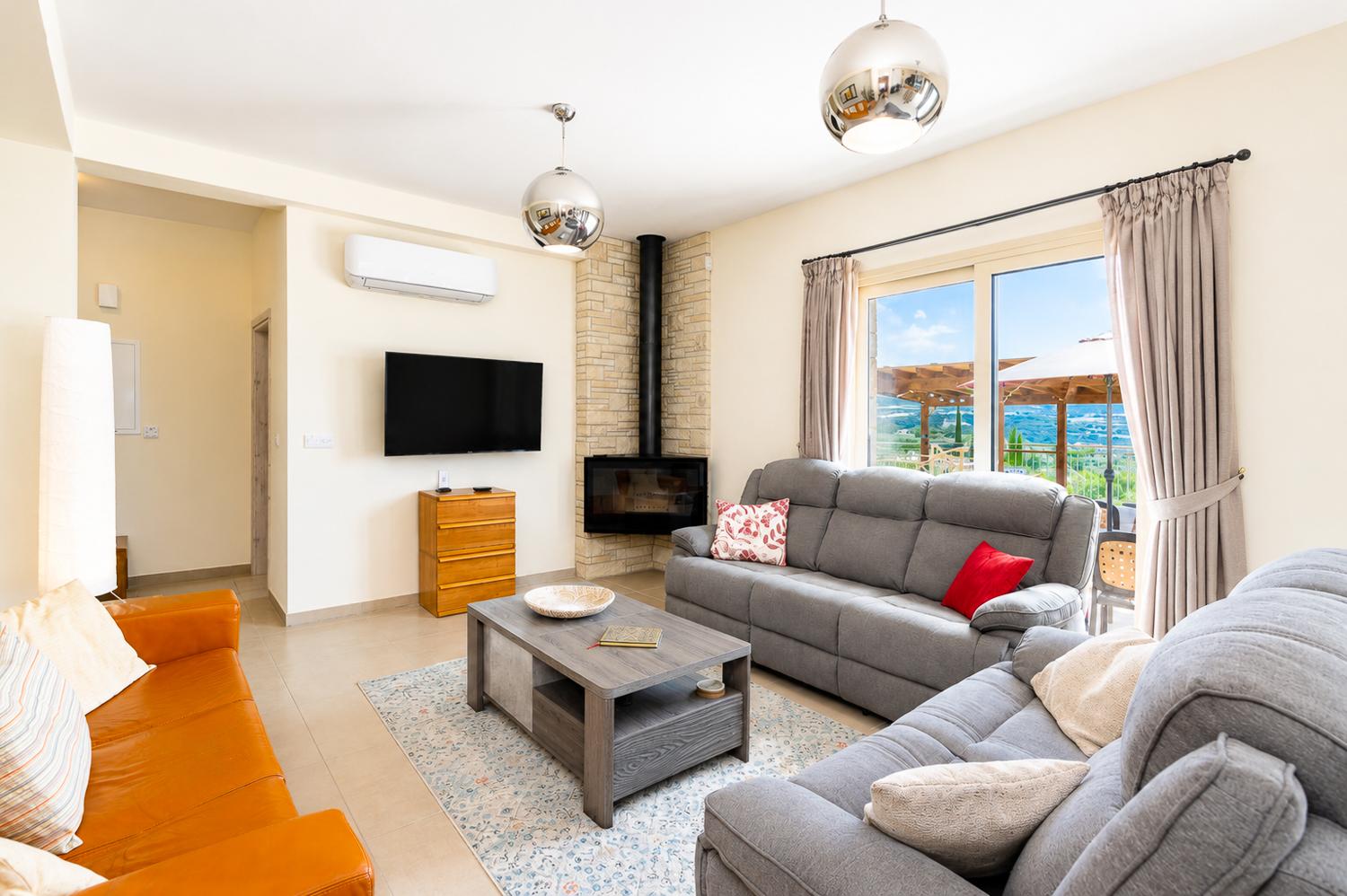Bright living room with comfortable sofas, modern decor, and lovely views from the terrace.