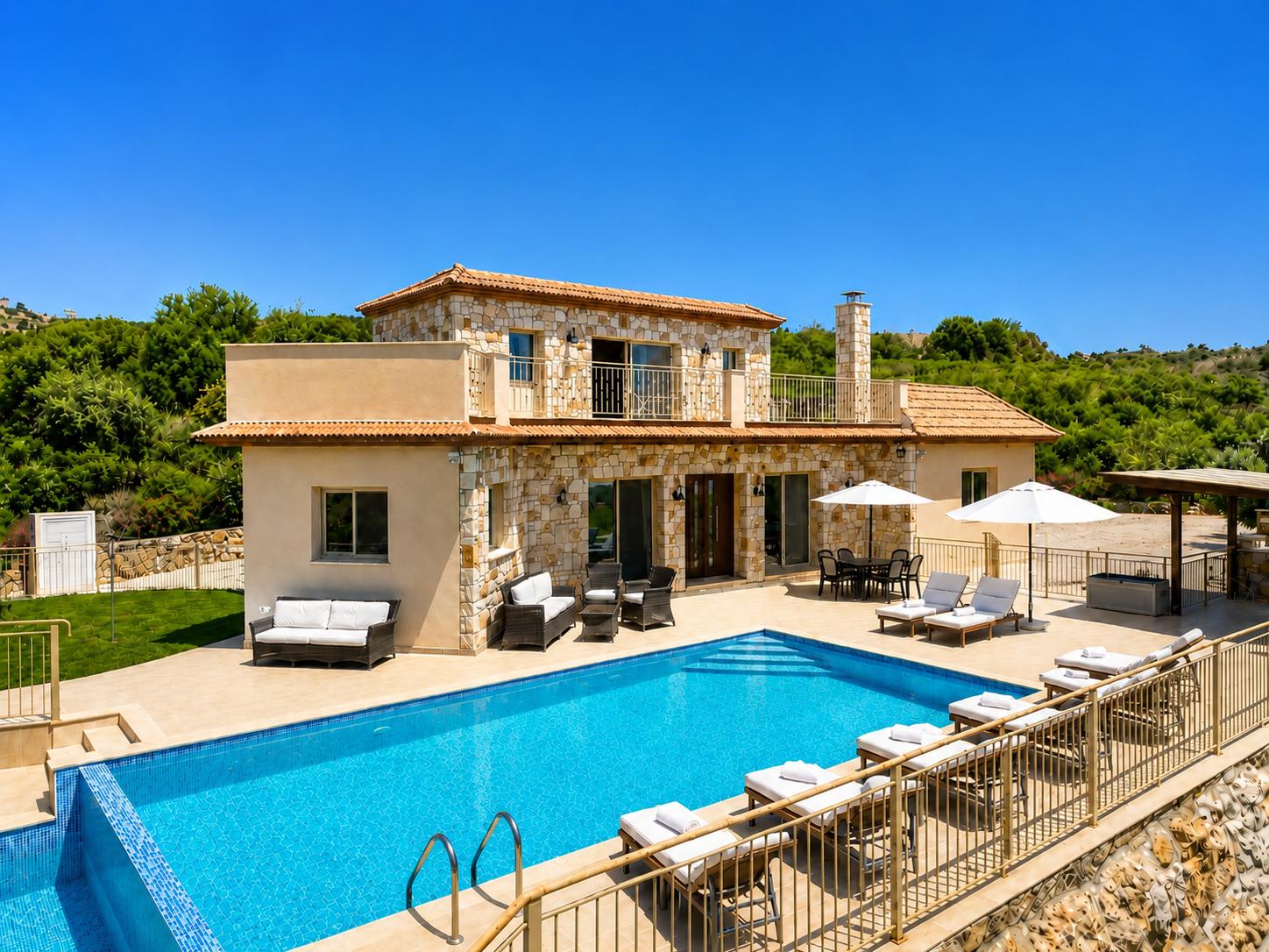 Spacious stone villa with a large private pool, sun loungers, and beautiful countryside surroundings.