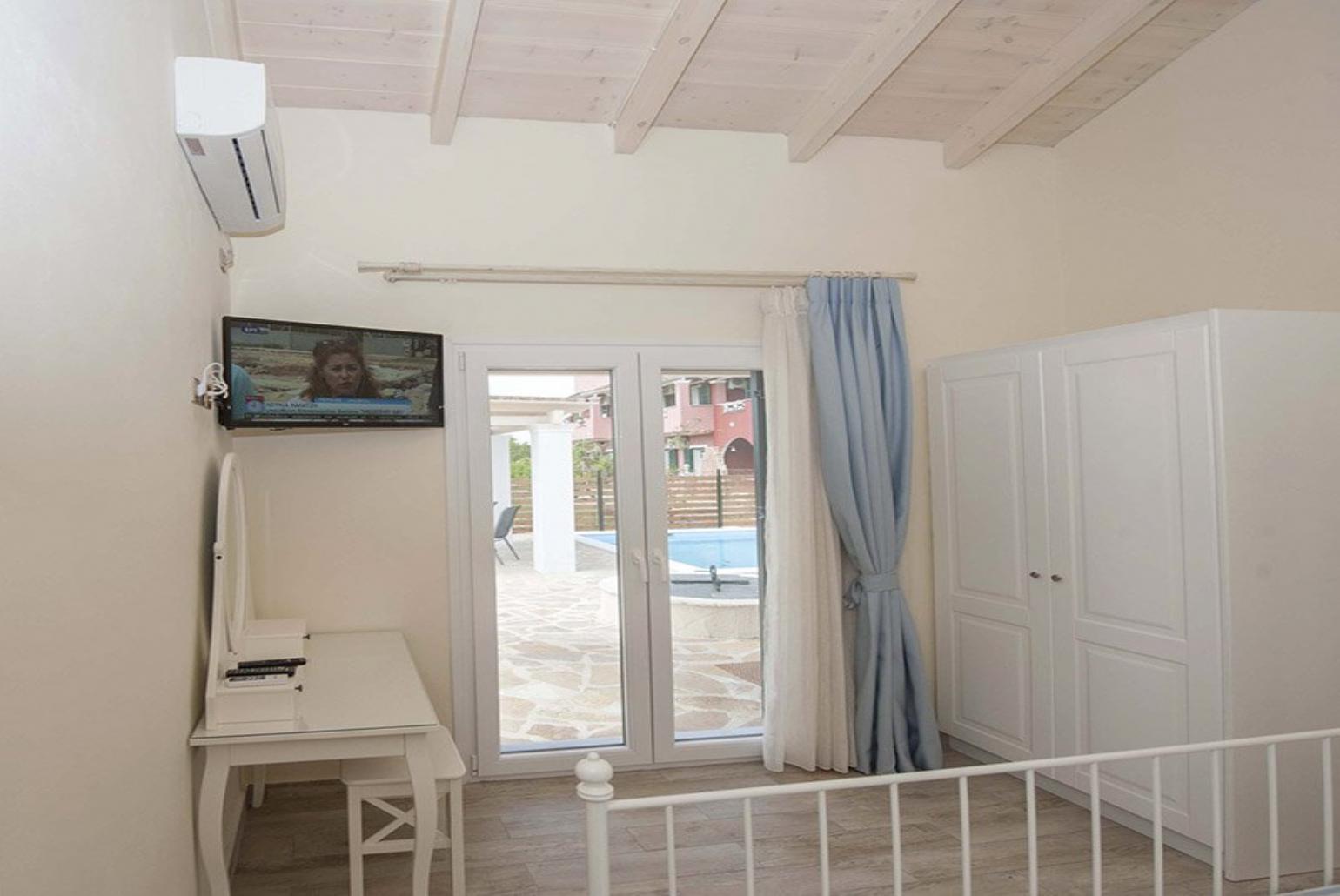 Double bedroom with A/C, TV and pool view
