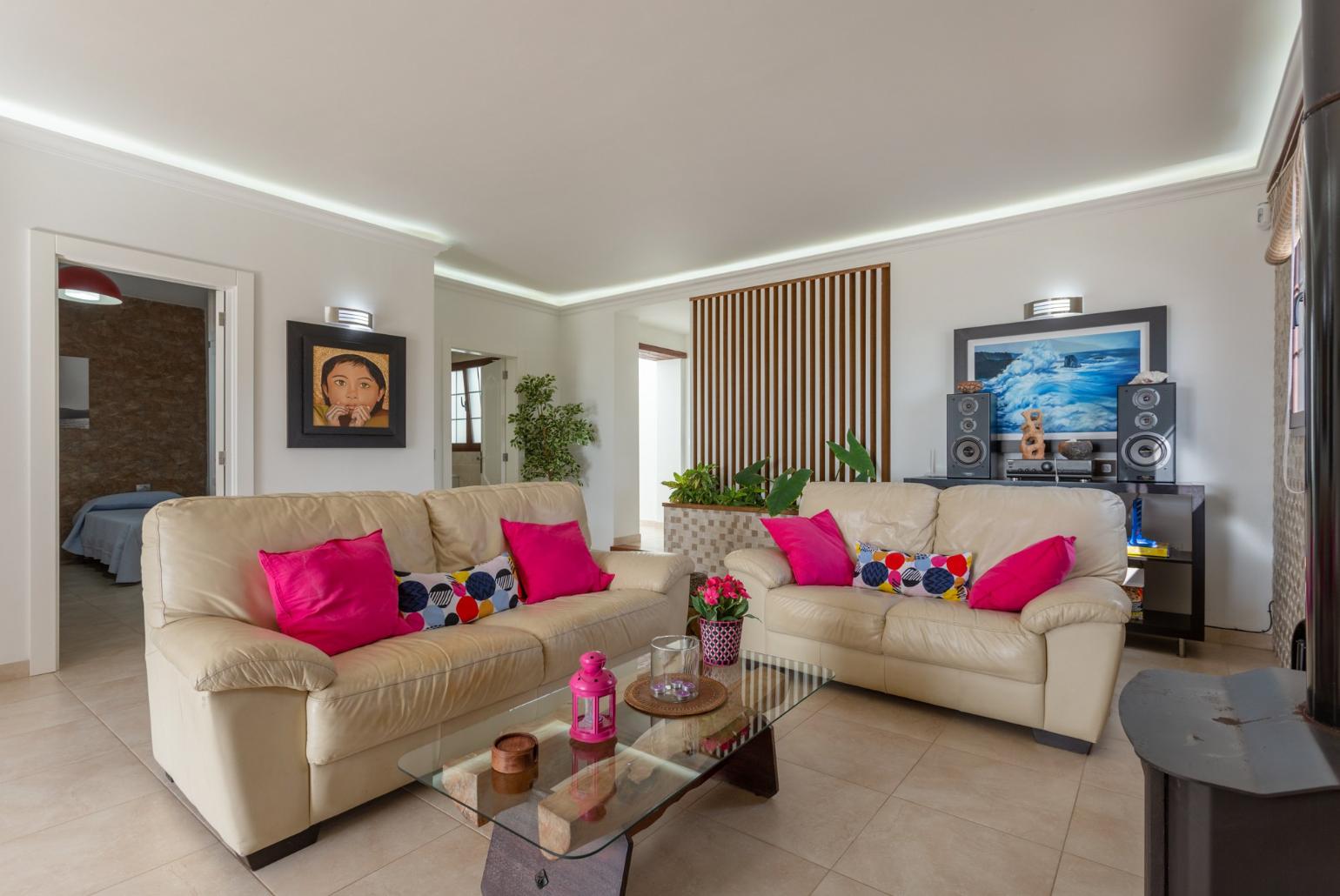 Open-plan living room with sofas, dining area, kitchen, ornamental fireplace, WiFi internet, satellite TV, DVD player, and pool terrace access