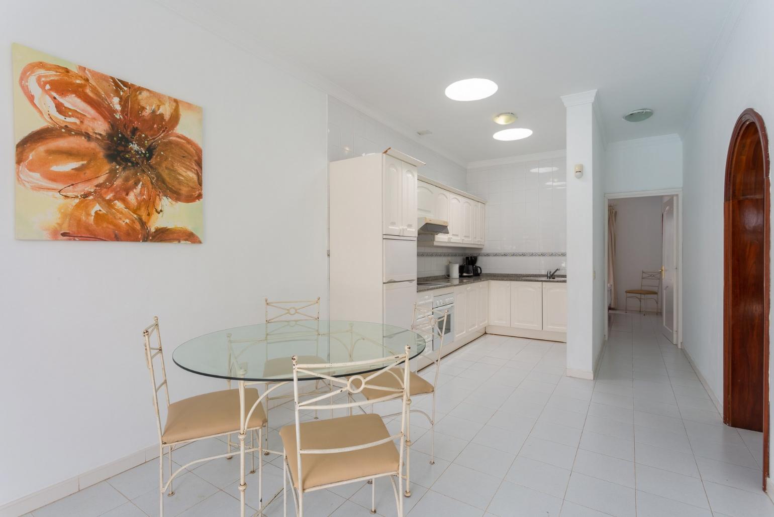 Open-plan dining area with equipped kitchen and terrace access