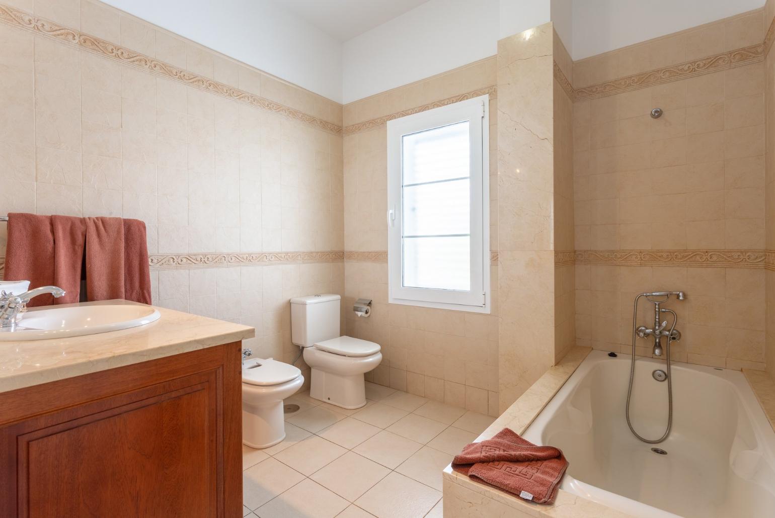 En suite bathroom with bath and overhead shower