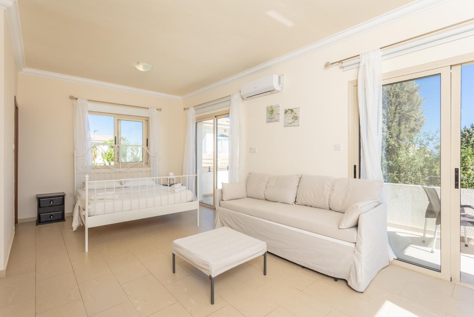 Double bedroom with en suite bathroom, sofa, A/C, and balcony access with sea views