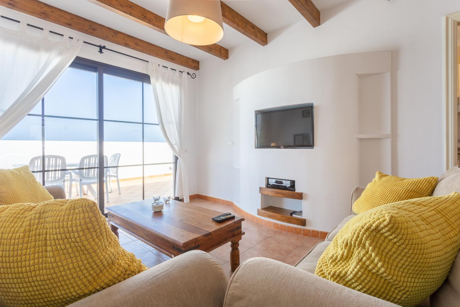 Open-plan living room with dining area, WiFi internet, satellite TV, and terrace access
