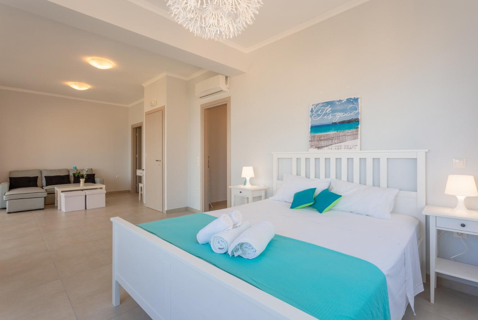 Double bedroom with en suite bathroom, A/C, living area, walk-in wardrobe, and balcony access