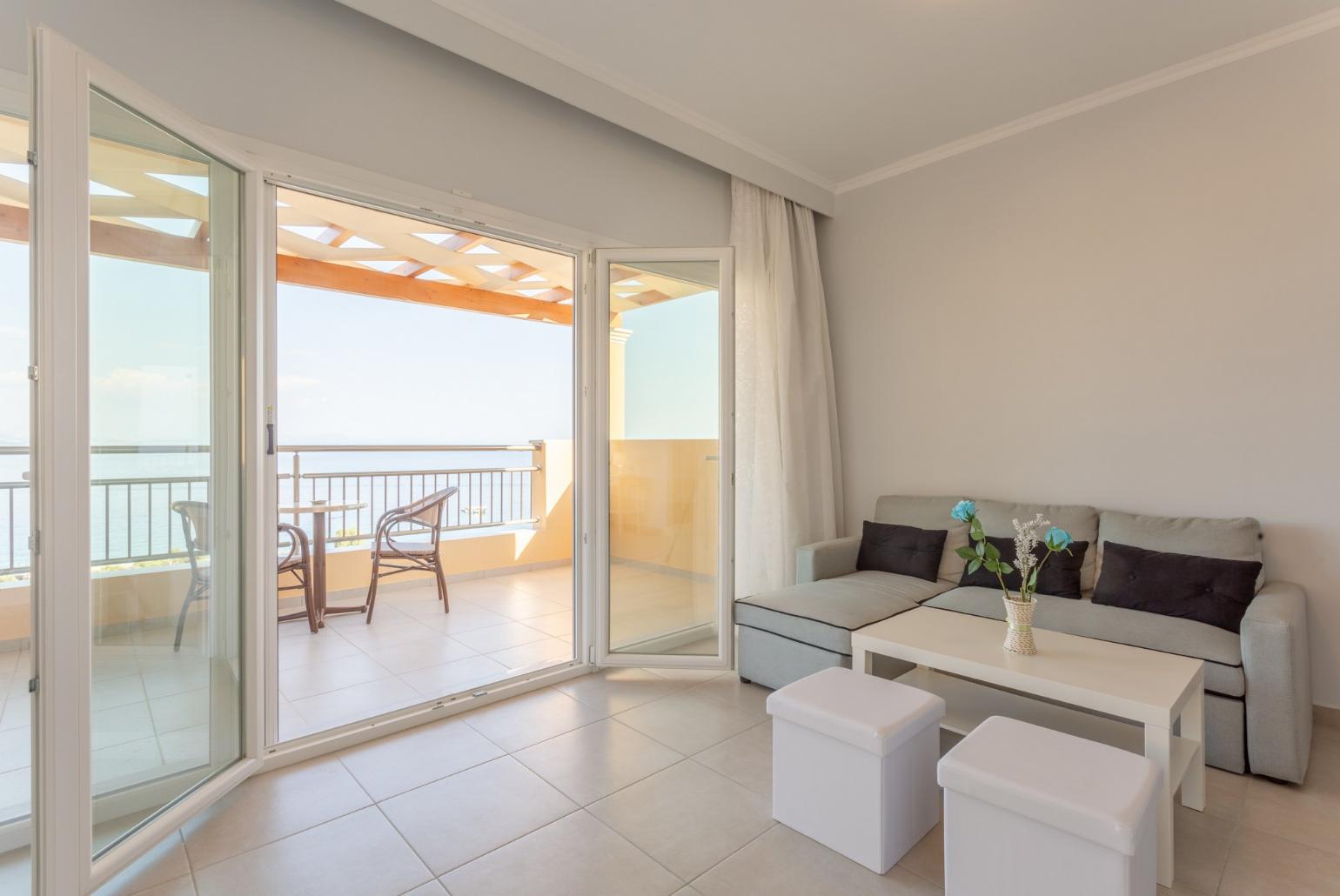 Double bedroom with en suite bathroom, A/C, living area, walk-in wardrobe, and balcony access