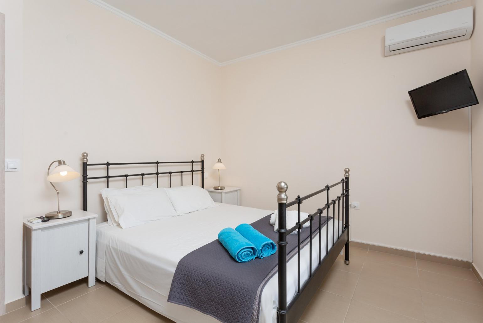 Double bedroom with en suite bathroom, A/C, TV, and balcony access with sea views