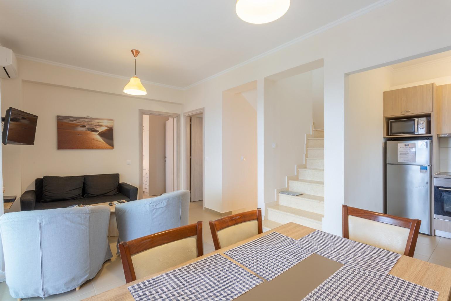 Open-plan living room with dining area, kitchen, A/C, WiFi internet, satellite TV, and balcony access with sea views 